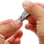 A person holding a small metal tool in their hand.